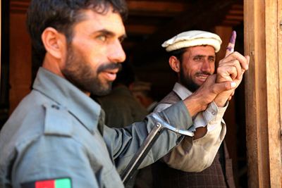 A voter shows an inked finger. The indelible ink is what the roll revision is argued over.